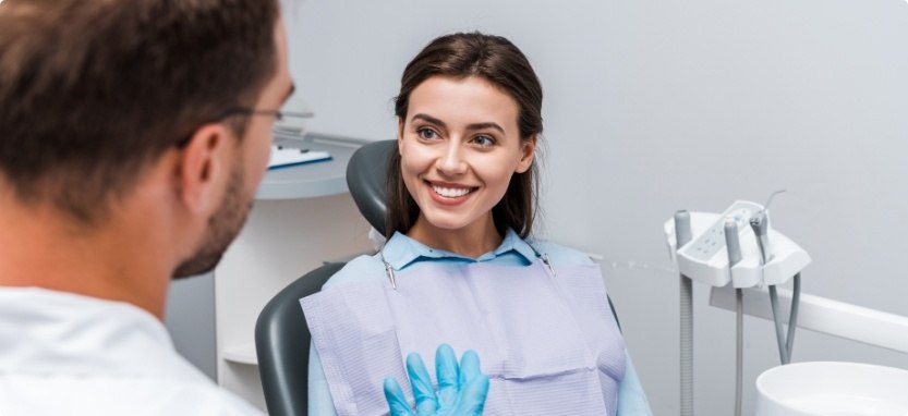 Smiling woman in dental chair talking to Waco dentist