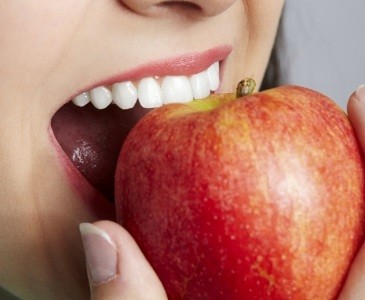 Person biting into red apple