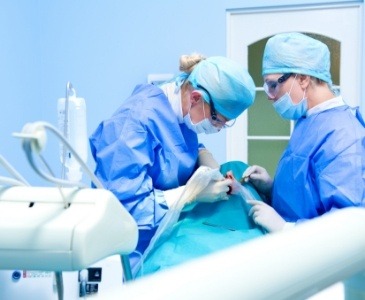 Two dentists performing dental implant surgery