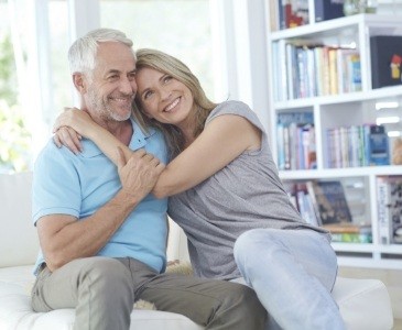 Man and woman hugging on their living room couch