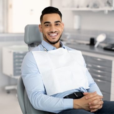 Man smiling while sitting in dental chair