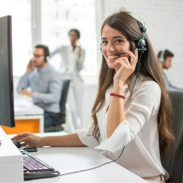 Dental team member smiling while talking on phone