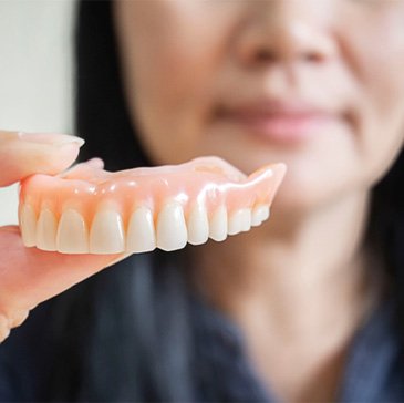 Woman holding a denture