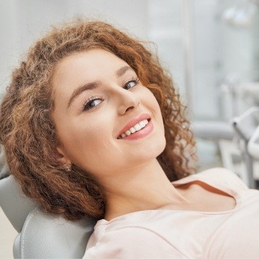 Woman smiling while leaning back in dental chair