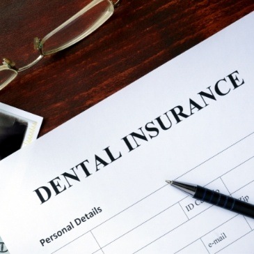 Dental insurance form on dark wood table