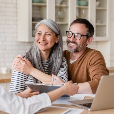 Smiling man and woman sitting at their kitchen table