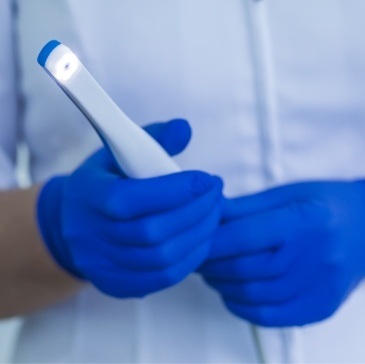 Gloved hands holding an intraoral camera