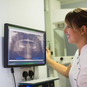 Dentist looking at digital dental x rays on computer screen
