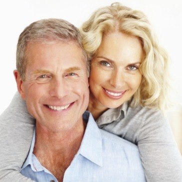 Smiling older man and woman holding each other