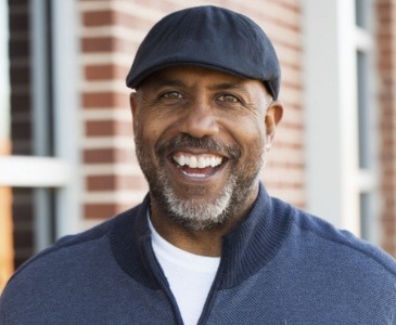 Smiling man in black hat outdoors