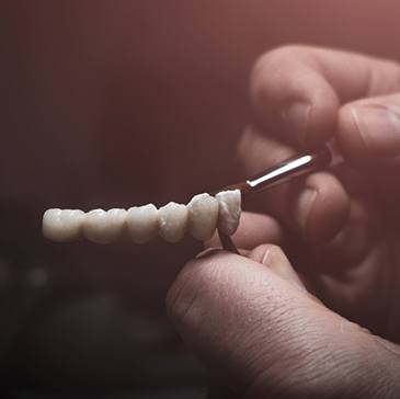 Lab technician painting replacement teeth