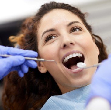 Woman receiving dental exam from emergency dentist in Waco