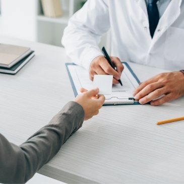 Patient handing a payment card to their dentist