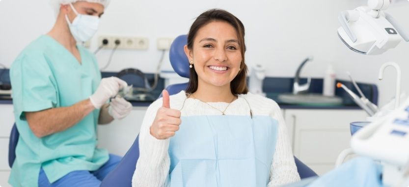 Smiling woman giving thumbs up while visiting Humana dentist in Waco