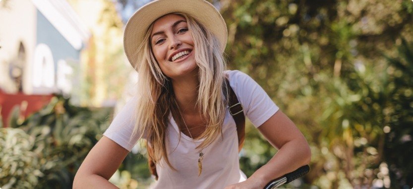 Woman with backpack smiling outdoors