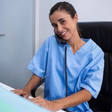 Dental team member smiling while talking on phone