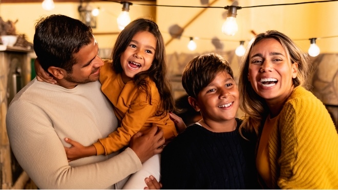 Family of four smiling in restaurant