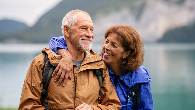 Senior man and woman wearing jackets on hike