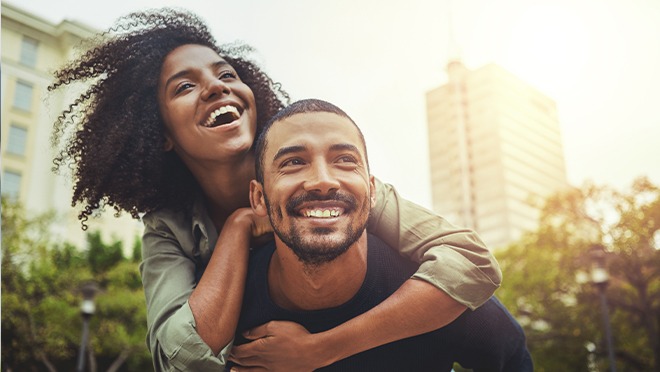 Man giving woman piggyback ride outdoors