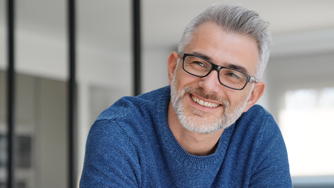 Smiling older man in glasses and blue sweater