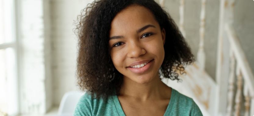 Young girl smiling with straight teeth thanks to Invisalign in Waco