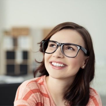 Young woman with glasses staring off into the distance