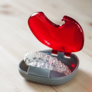 Invisalign aligners in red and gray storage case