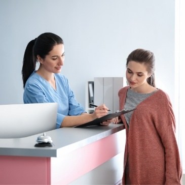 Dental team member showing a clipboard to a patient