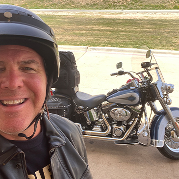 Doctor Cofer taking selfie with his motorcycle in the background