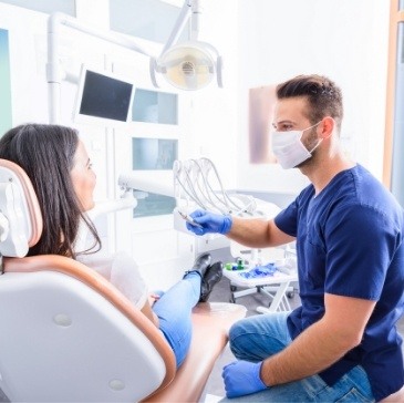 Dentist talking to patient in dental chair