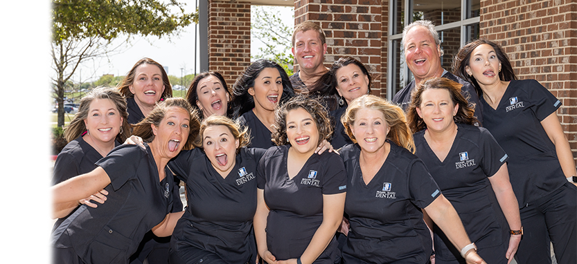 Waco dental team smiling outside of Premier Family Dental office
