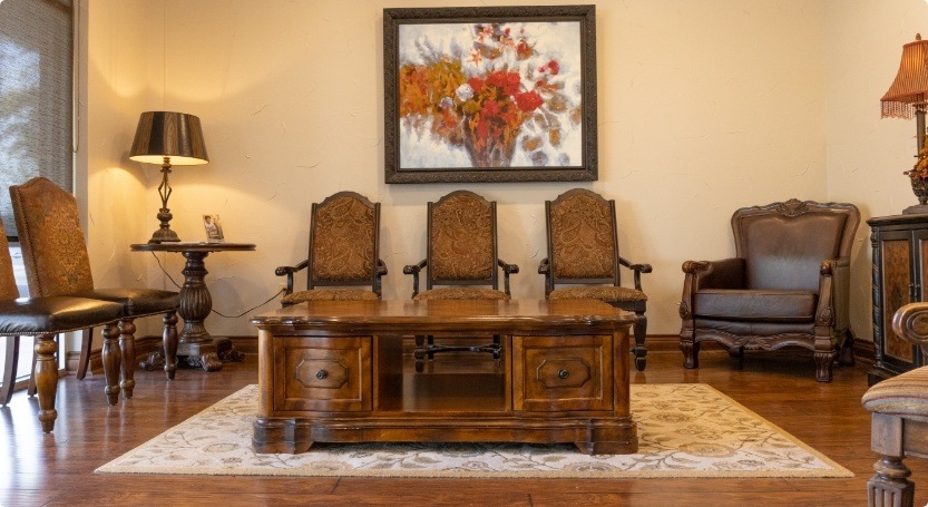 Ornate wooden desk surrounded by chairs in dental office waiting room