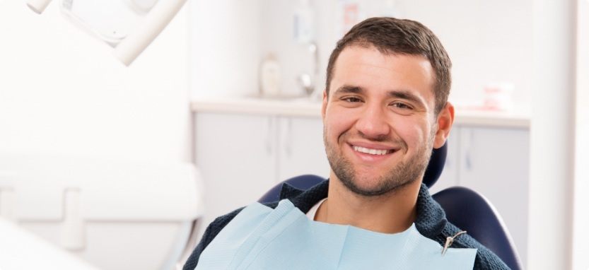 Dental patient smiling before oral cancer screening in Waco