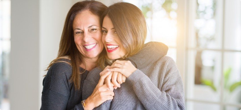 Two woman hugging after root canal treatment in Waco