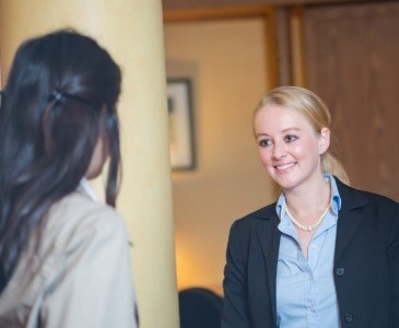 Dental team member talking to dental patient at front desk