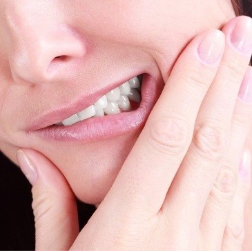 Close up of person holding their jaw in pain