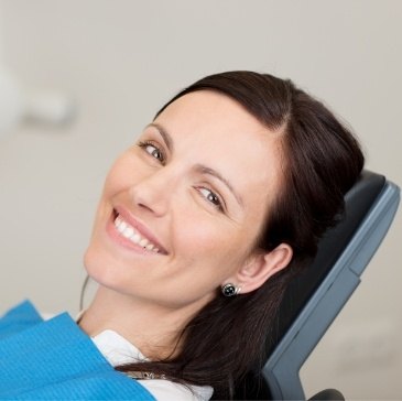 Smiling woman leaning back in dental chair