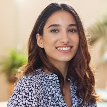 Smiling woman in black and white flowery blouse