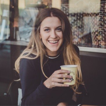 Woman sitting at table holding coffee cup