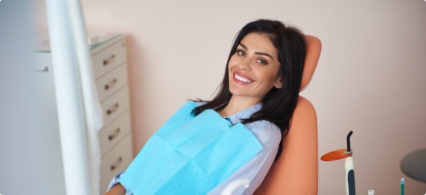 Smiling woman leaning back in dental chair