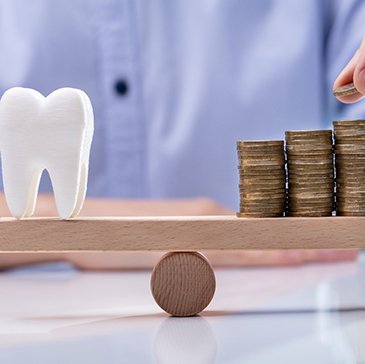 Tooth being balanced against a stack of coins
