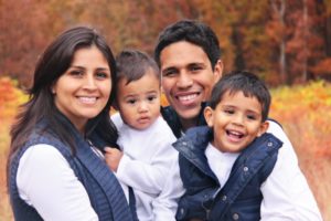 family of four hugging laughing