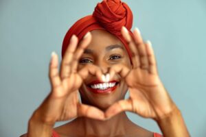 Woman using her hands to make heart shape around her smile