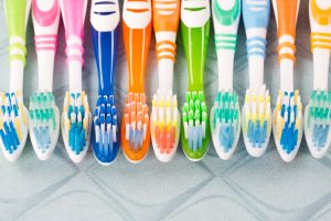 multi colored toothbrushes in a row
