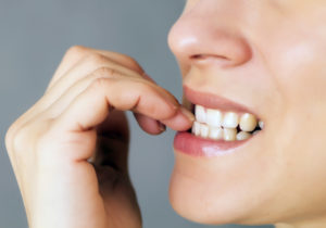 woman stressed biting nails