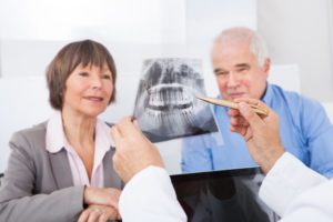 A dentist showing an X-ray to patients.