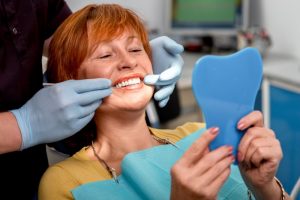 An older woman examining her new smile.