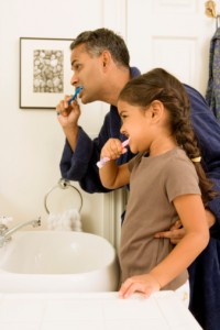 Father and daughter brushing teeth with toothbrush recommended by Waco Dentist Premier Family Dental