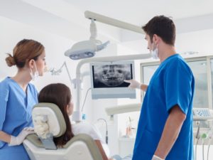 dentist showing dental x-ray to patient who needs wisdom tooth extractions in Waco