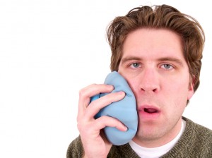 man holding ice pack to his face has a toothache and needs the relief of a root canal waco residents rely on